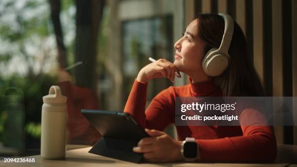 asian woman drawing on her tablet. - digitized pen stock pictures, royalty-free photos & images