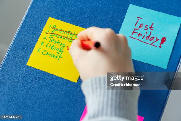 child crossing off completed tasks on a daily planner sticky note - labelling stock pictures, royalty-free photos & images