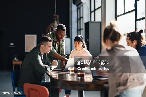 Une équipe diversifiée travaillant ensemble dans un espace de coworking moderne Une équipe diversifiée travaillant ensemble dans un espace de coworking moderne