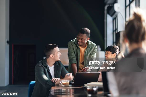 team eterogenei che collaborano in un moderno spazio di co-working - vicinanza foto e immagini stock