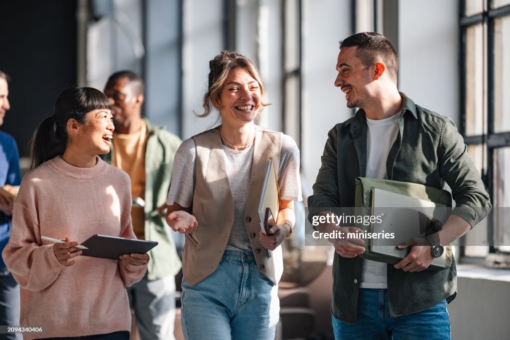 Young Professionals Engaged in a Lively Discussion at a Co-Working Space