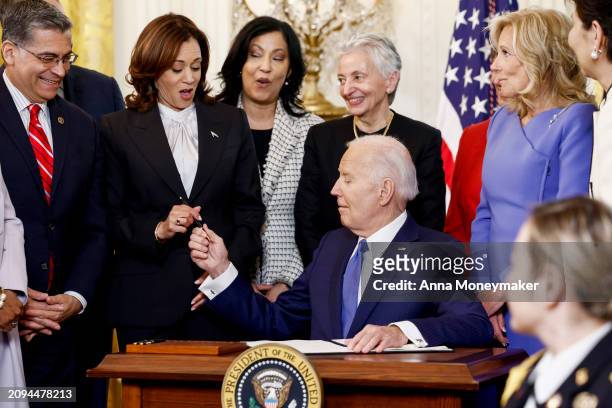 President Joe Biden looks to U.S. Vice President Kamala Harris as he signs an executive order designated to the study of women's health during a...