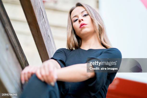 portrait of young woman wearing a black blouse and posing on some wooden fences at the san fermin festivities, pamplona, ​​spain - fiesta of san fermin stock pictures, royalty-free photos & images