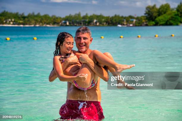 vacation. man with daughter laughing and joking in the tropical waters. - mauritius stock pictures, royalty-free photos & images