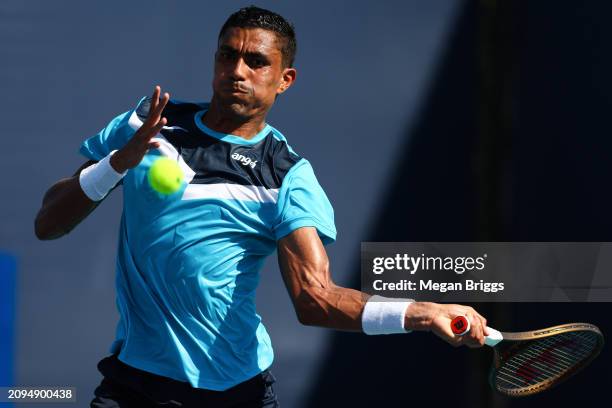 Thiago Monteiro of Brazil returns a shot to Adam Walton of Australia during his men's singles qualifying match against during the Miami Open at Hard...