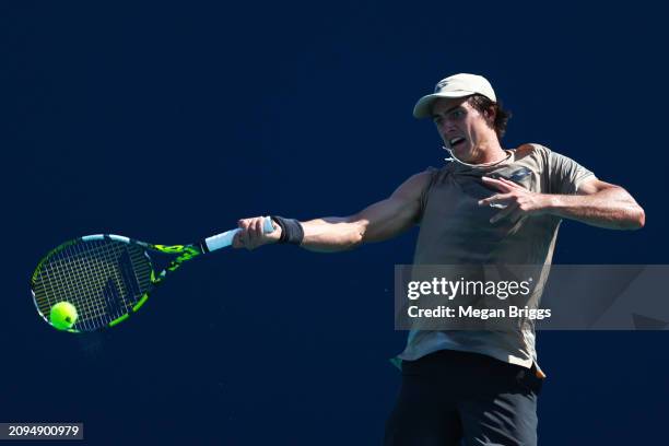 Adam Walton of Australia returns a shot to Thiago Monteiro of Brazil during his men's singles qualifying match against during the Miami Open at Hard...