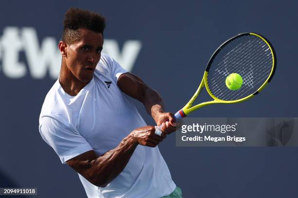 Michael Mmoh of the United States returns a shot to Brandon Nakashima of the United States during his men's singles qualifying match against during...