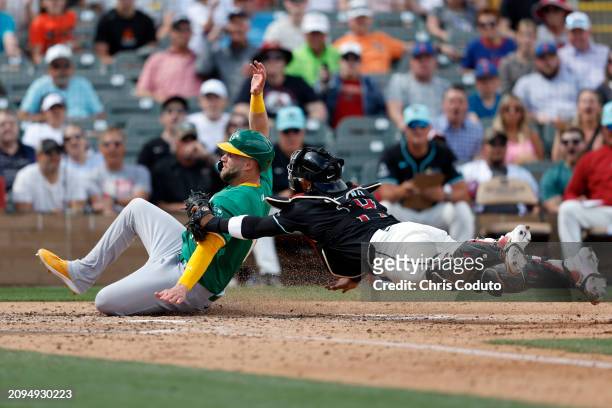 Seth Brown of the Oakland Athletics is tagged out by Gabriel Moreno of the Arizona Diamondbacks while attempting to score a run during the fifth...