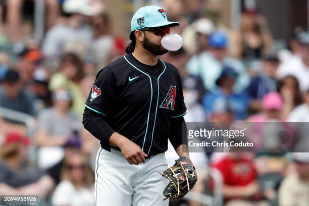 Eugenio Suarez of the Arizona Diamondbacks blows a bubble during a spring training game /aoaat Salt River Fields at Talking Stick on March 18, 2024...