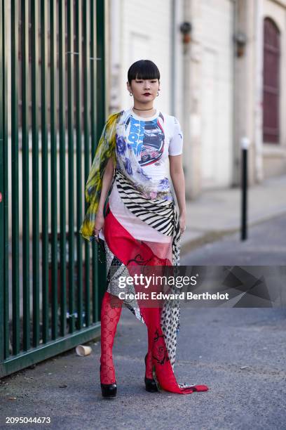 Akimoto Kozue wears a multicolored asymmetric dress, red tights, black pumps, outside Marine Serre, during the Womenswear Fall/Winter 2024/2025 as...