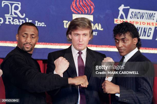Billionaire Real Estate Developer Donald Trump puts 15 February 1990 in New York his fists in the air as Thomas "The Hitman" Hearns and Michael "The...