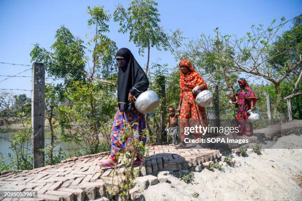 People are going to a pond to collect drinking water at Shyamnagar Gabura in Satkhira district. In Gabura Union, located in Shatkhira District,...