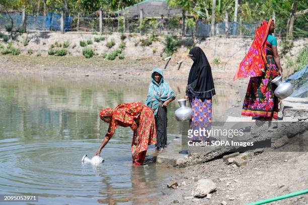 Women collecting drinking water from a pond at Shyamnagar Gabura in Satkhira district. In Gabura Union, located in Shatkhira District, southern...