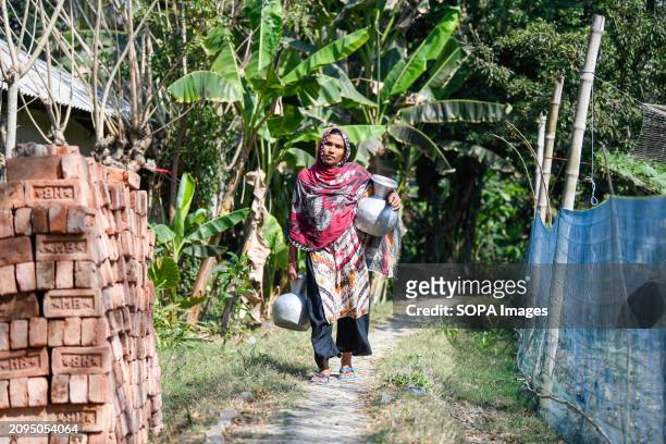Woman is returning from collecting drinking water from a reverse-osmosis plant set up by a local Non-Governmental Organisation at Shyamnagar Gabura...