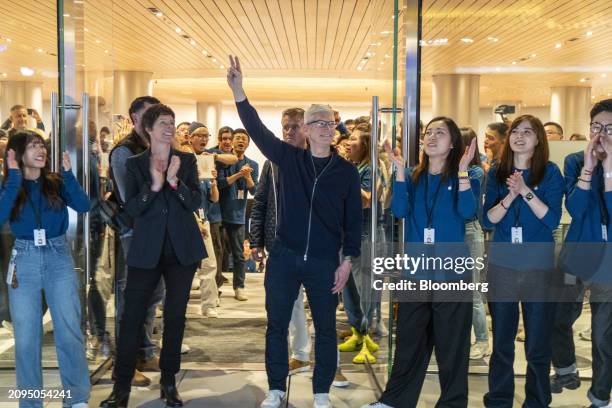 Tim Cook, chief executive officer of Apple Inc., center, and Deirdre O'Brien, senior vice president of retail, left, during the opening of the new...