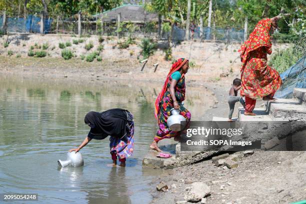 Women collecting drinking water from a pond at Shyamnagar Gabura in Satkhira district. In Gabura Union, located in Shatkhira District, southern...