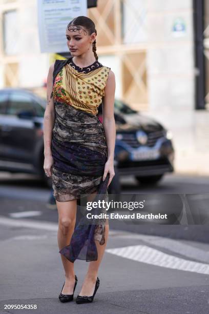 Guest wears a yellow and black draped mini dress, black pumps, outside Marine Serre, during the Womenswear Fall/Winter 2024/2025 as part of Paris...