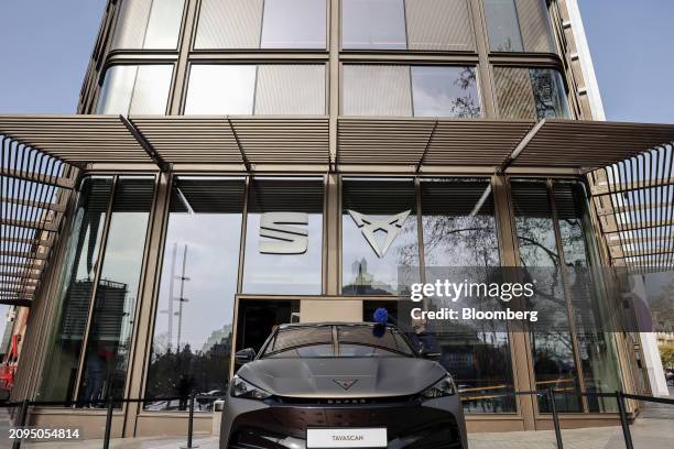 Worker dusts the bodywork of a Cupra Tavascan electric sports utility vehicle outside Casa Seat in Barcelona, Spain, on Thursday, March 21, 2024....