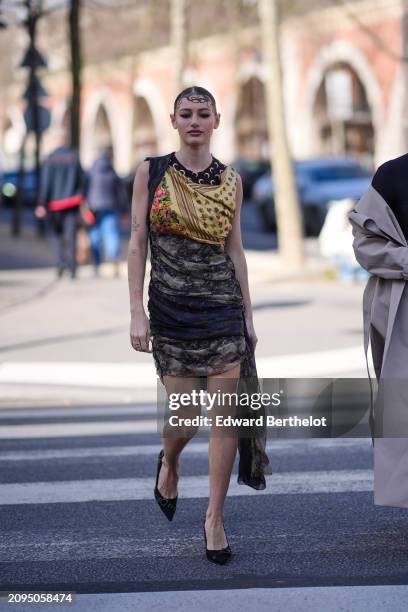 Guest wears a yellow and black draped mini dress, black pumps, outside Marine Serre, during the Womenswear Fall/Winter 2024/2025 as part of Paris...