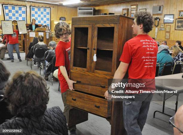 Meissner's Auction Service workers carry out a chest sold during Saturday's weekly auction March 19, 2016 in New Lebanon, NY.