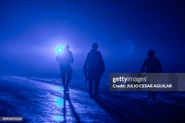 Members of the Mexican Army guard the area in which a charred vehicle and around 10 charred bodies were found, in a section of the Miguel Aleman-Ojo...