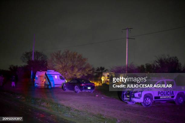 Members of the Mexican Army and municipal police guard the area in which a charred vehicle and around 10 charred bodies were found, in a section of...