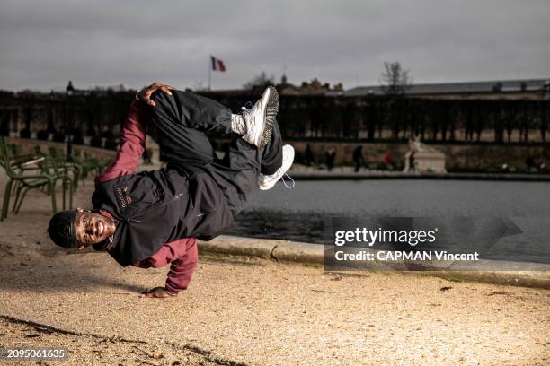 Attitude souriante de Dany DANN, 35 ans, danseur de breaking, ou b-boy, exécutant la figure "air chair", en se tenant sur une seule main, dans le...