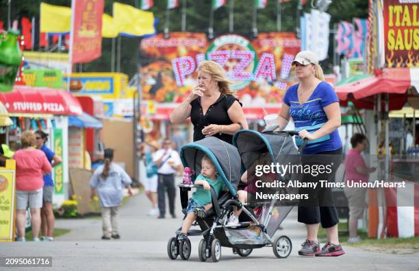 Micki Hughes, center, of Queensbury, her daughter Lindsay Hughes and grandchildren Alexa and Luke take in the midway during opening day at the...