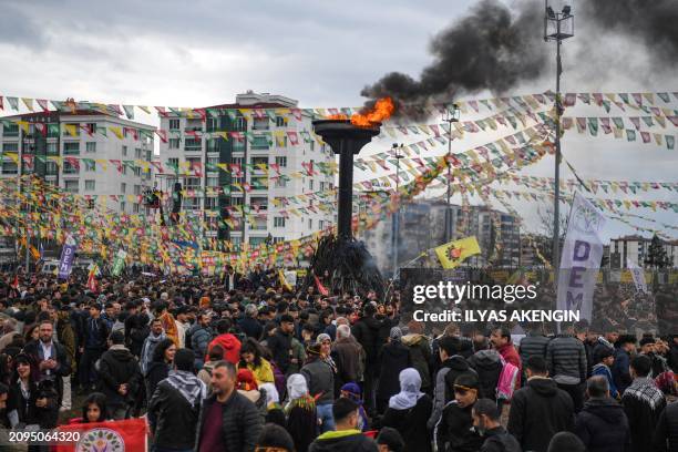 Turkish Kurds gather around a bonfire pyre during Nowruz celebrations marking the Persian New Year in Diyarbakir, southeastern Turkey on March 21,...