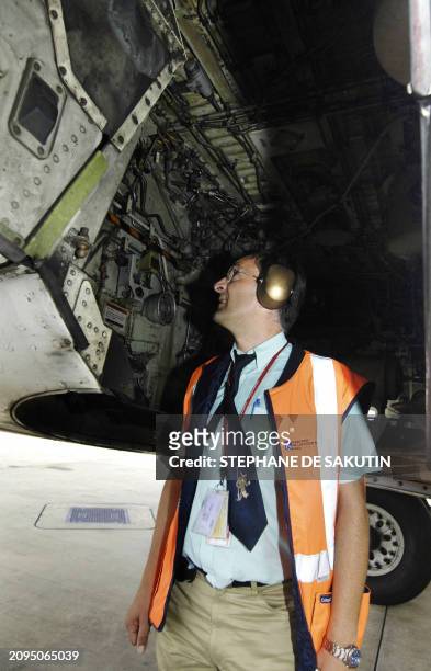 Thierry Le Verrier, contrôleur technique d'exploitation, employé de la Direction générale de l'aviation civile, vérifie un avion, le 23 août 2005 sur...