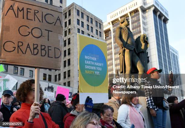 Resistance Day of Action demonstrators stand on the base of the George Washington statue during a rally on the lawn of the Capitol Saturday Jan. 21,...