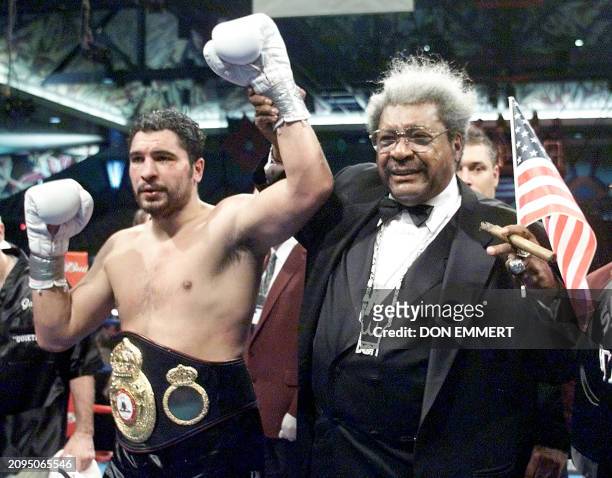 Boxing promoter Don King raises the arms of John Ruiz after Ruiz fought to a draw with Evander Holyfield in their World Boxing Association...