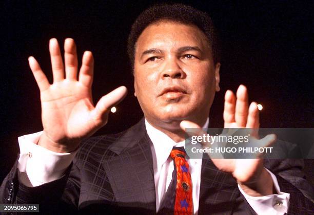 American boxer Muhamed Ali performs a magic as he and British colleague Lennox Lewis launch a new Playstation game called "Knockout Kings" in London,...