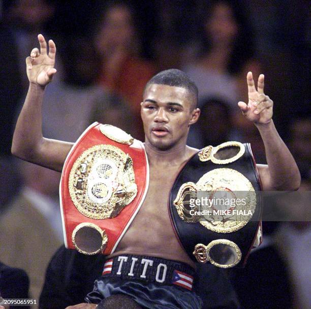 Felix Trinidad of Puerto Rico flashes the V-sign as he wears the championship belts after defeating Mexican-American Fernando Vargas in a 12-round...