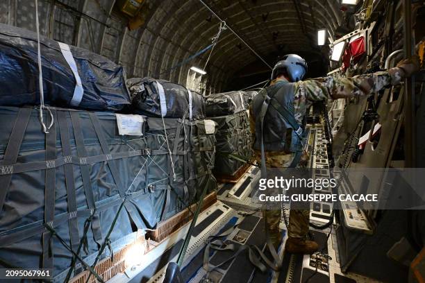 Picture taken on March 21, 2024 onboard a US military transport aircraft shows humanitarian aid parcels intended for the Gaza Strip loaded onto the...
