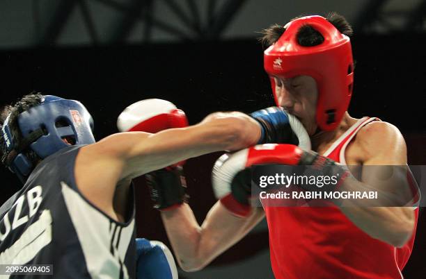 Bahodirjon Sultanov of Uzbekistan punches Kim Song Guk of North Korea in the men's boxing feather 57kg quarter-final during the 15th Asian Games in...