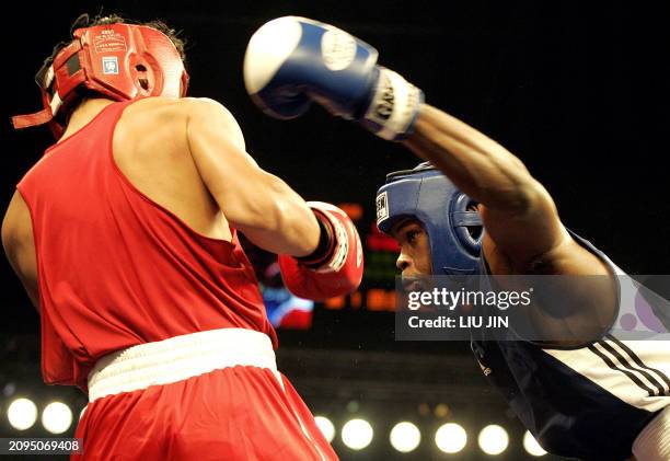 Emilio Correa Bayeux of Cuba launches a hook to Qi Jing of China during their 75 kg category preliminary match of the 13th World Senior Boxing...