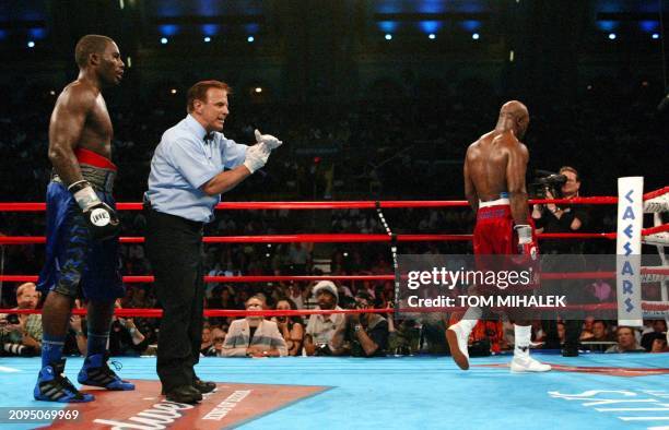Referee Tony Orlando signals time out in the eighth round after sending Evander Holyfield to a neutral corner as Hasim Rahman stands in the ring with...