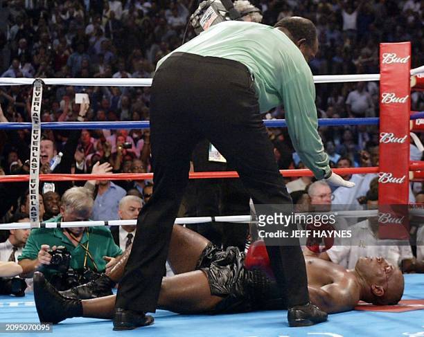 Challenger Mike Tyson of the US is counted out by referee Eddie Cotton after being knocked out by Heavyweight Champion Lennox Lewis of England during...