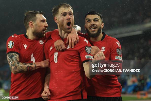 Georgia's forward Budu Zivzivadze celebrates with teammates after scoring the team's first goal during the UEFA EURO 2024 qualifying play-off...