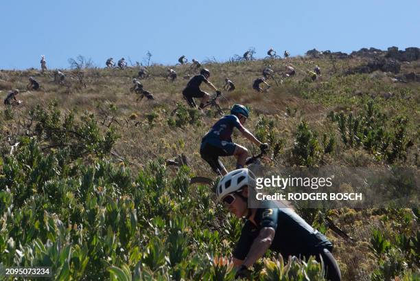 Competitors ride during Stage 4 of the 2024 Cape Epic mountain bike race on March 21, 2024 in the mountains above the town of Wellington. In this...
