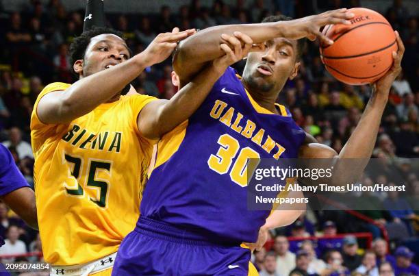 Siena's Sammy Friday, left, and Albany's Travis Charles tangle during their Albany Cup game at the Times Union Center Saturday Dec. 9, 2017 in...