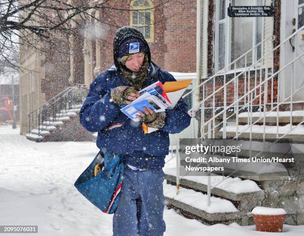 Letter carrier Justin Whating delivers mail as snow falls Wednesday Feb. 7, 2018 in Schenectady, NY.