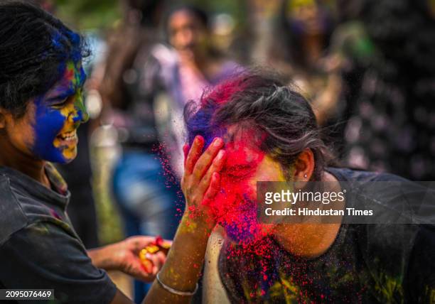 Students play with colours ahead of Holi festival, at outside the Matasundari College, ITO on March 21, 2024 in New Delhi, India.
