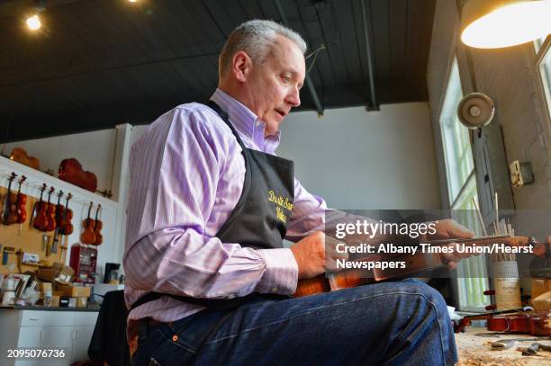 Violin maker Dustin Saam at work in his studio in The Shirt Factory, artists studios, shoppes and galleries in the former McMullen-Leavens Shirt...