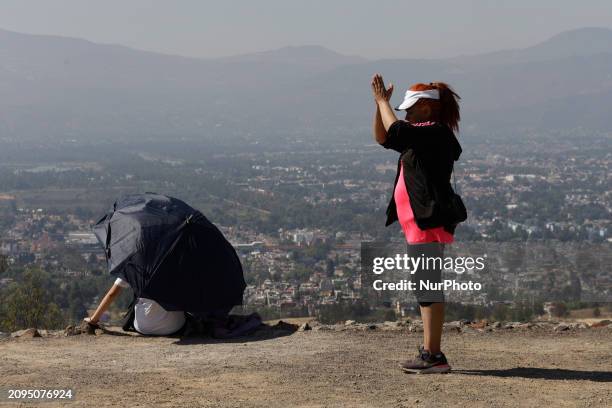 Person is visiting the Cerro de la Estrella archaeological site in Mexico City, where they are performing various rituals by raising their arms to...