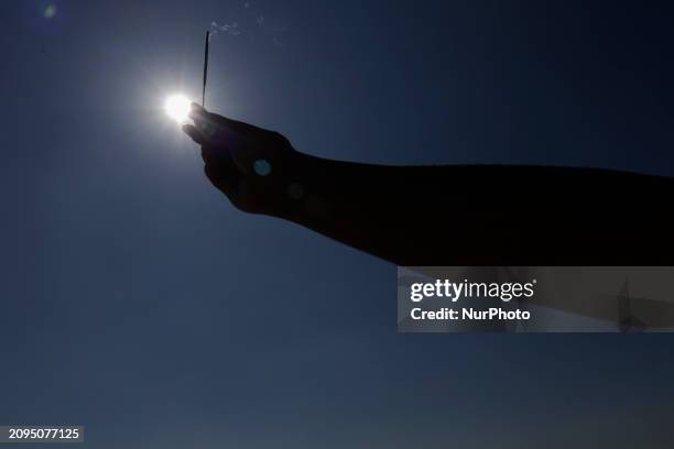 Group of people is visiting the Cerro de la Estrella archaeological site in Mexico City, where they are performing various rituals by raising their...