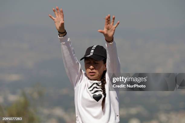 Person is visiting the Cerro de la Estrella archaeological site in Mexico City, where they are performing various rituals by raising their arms to...