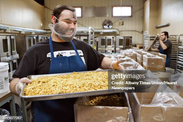 Roaster Jon Doty with a tray of salted cashew pieces in the roasting room at the Tierra Farm production facility and retail store Friday March 9,...