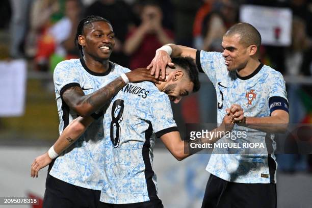 Portugal's midfielder Bruno Fernandes is congratulated for scoring his team's third goal by Portugal's forward Rafael Leao and Portugal's defender...